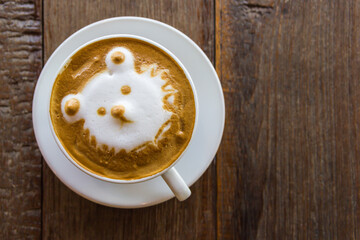 Black coffee latte art face bear image in white cup on wood table