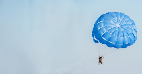 Man flying in the sky on a parachute.