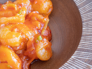 海老とネギがたくさん入った中華料理のエビチリのクローズアップ。