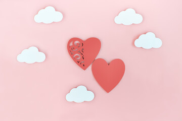 red hearts and clouds on a pink background. valentines day and love concept. wedding symbol. support and togetherness. copy space. top view.