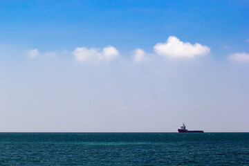 Cargo ship in the blue sea and blue sky background