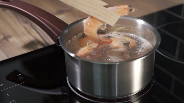 Throwing shrimp into a cooking pot in slow motion