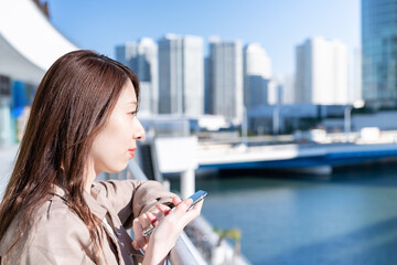 Fototapeta premium スマートフォンを持つ若い女性 ビジネスウーマン