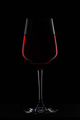 a glass of wine in a contrasting light on a black background