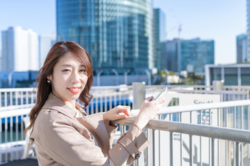 Fototapeta premium スマートフォンを持つ若い女性 ビジネスウーマン