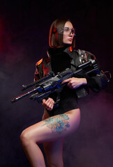 Naklejka premium Sexual female warrior with nude and tattooed legs poses in dark and smokey background. Armed with futuristic armed beautiful woman with cybernetic implant.