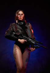 Obraz na płótnie Canvas Martial and futuristic woman with implant and glasses posing in studio. Portrait of a attractive and sexy female soldier in black clothing with glasses and tattooed nude legs in dark background.