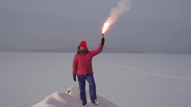 Girl holding a lit flare in her hands, slow motion