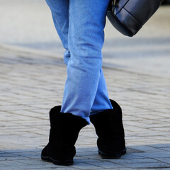 Legs of a girl standing on the sidewalk