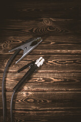 Welding wires on a wooden background. Place for the text. Studio photo in hard light.