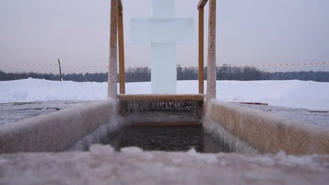 A hole for bathing on the feast of Epiphany. Outdoor plunge pool, the lake. A cross made of ice