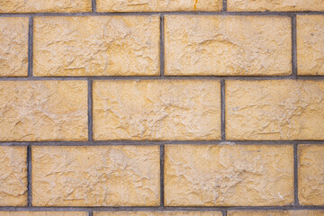 Background from a wall with beige block-shaped bricks