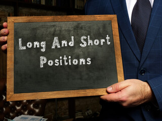 Financial concept meaning Long And Short Positions with inscription on the black chalkboard.