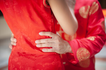 Couples grab the waist together in red clothes