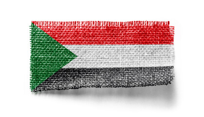 Sudan flag on a piece of cloth on a white background