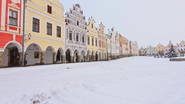 Main square of Telc with its famous 16th-century colorful houses, a UNESCO World Heritage Site since 1992, on a winter day with falling snow.