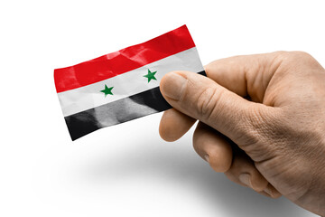 Hand holding a card with a national flag the Syria