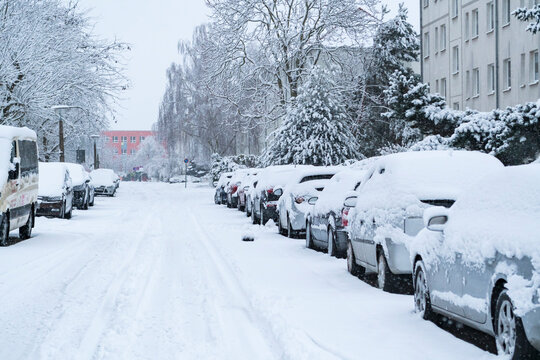 Eingeschneite parkende Autos bei Schneefall