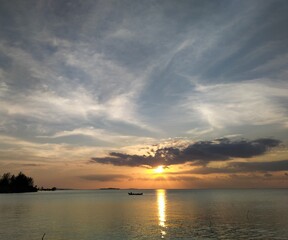 Fototapeta na wymiar A boat and sunset over the ocean