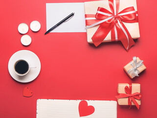 Gifts with notebook and cup of coffee on color background