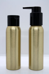 Two gold bottles for cosmetics.
