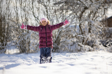 A child girl on a walk in a winter park