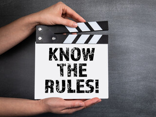 Obraz premium KNOW THE RULES! Business background. Movie clapper in woman hand. Black chalk board background