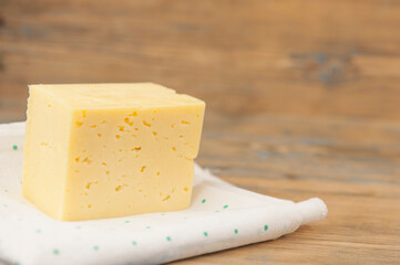 a block of cheese on the wood table