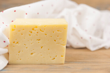 a block of cheese on the wood table