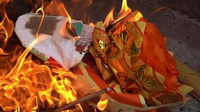 Slow motion burning joss paper at furnace at chinese temple at Penang, Malaysia.