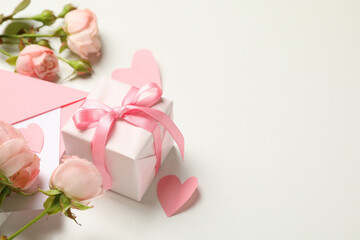 Envelope, roses, hearts and gift box on white background