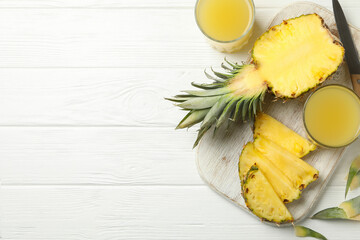 Concept of breakfast with pineapple and glasses with juice on wooden table, top view