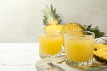 Concept of breakfast with pineapple and glasses with juice on wooden table