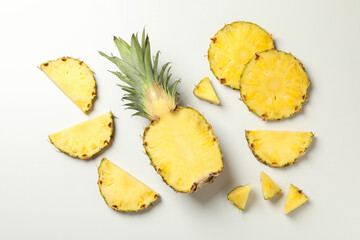 Flat lay with pineapple and slices on white background