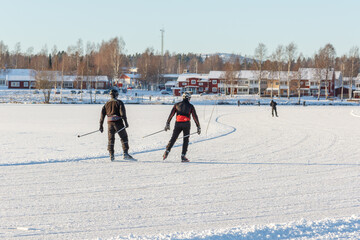 three people skating on a frozen lake