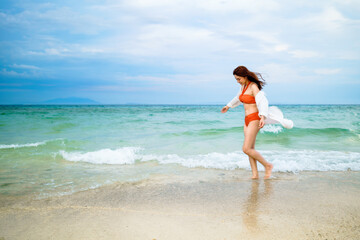 Fototapeta na wymiar happy woman in the sea beach at Koh MunNork Island, Rayong, Thailand, pronounced motion blur
