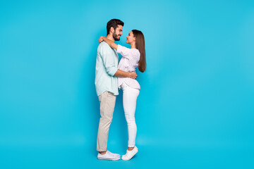 Full size profile photo of two lovely nice people embrace look each other eyes isolated on blue color background