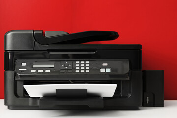 Modern printer with paper on red background