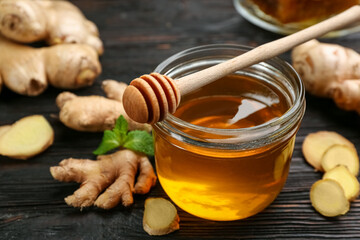 Honey and ginger on black wooden table, closeup. Natural cold remedies