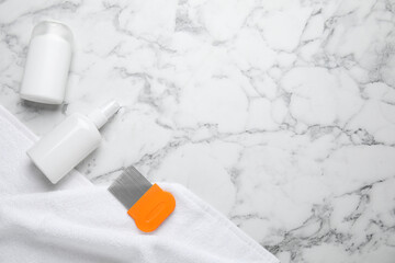 Products for anti lice treatment, metal comb and towel on marble background, flat lay. Space for text
