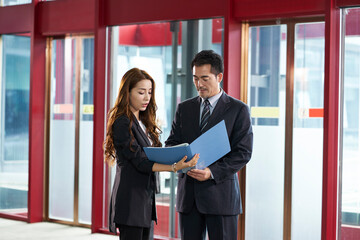 asian corporate executives discussing business in company lobby