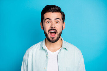Photo of amazed handsomeyoung happy man surprised information discount isolated on blue color background