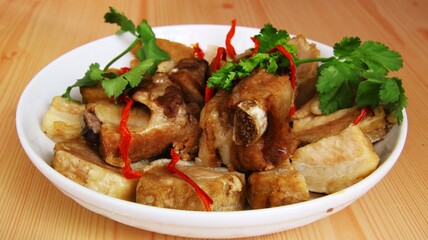 pork ribs garnished and red bell peppers in white porcelain plate