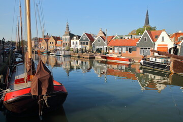 Fototapeta premium The harbor of Monnickendam, North Holland, Netherlands, with reflections of historic houses and old wooden boats