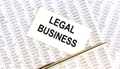 Obraz premium On the business card the text of Legal Business, next to the pen, the background are reports.