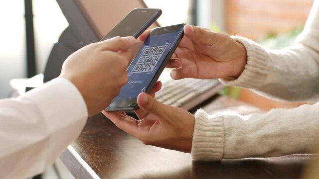 Customer using phone for payment at cafe restaurant, cashless technology and money transfer concept