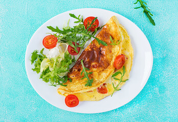 Breakfast. Omelette with tomatoes, cheese and arugula on white plate.  Frittata - italian omelet. Ketogenic, keto food. Top view, flat lay