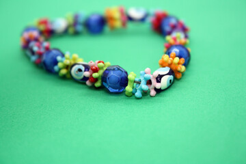 A bracelet made of beads on a pink background.