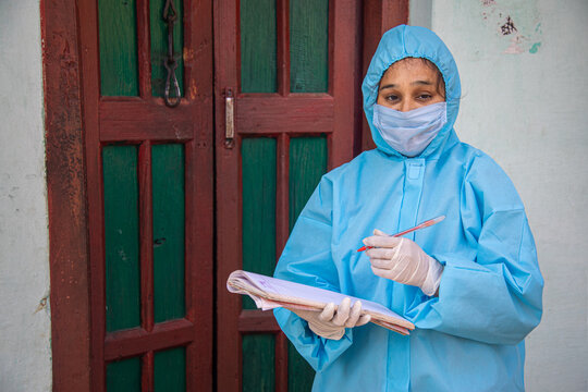 Women Nurse Workers In Ppe Kit Doing Door To Door Surveys In Indian Village Regarding Covid-19