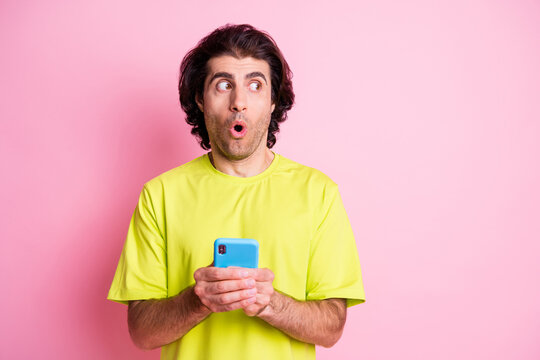 Photo portrait of amazed shocked male influencer staring blank space isolated on pastel pink color background